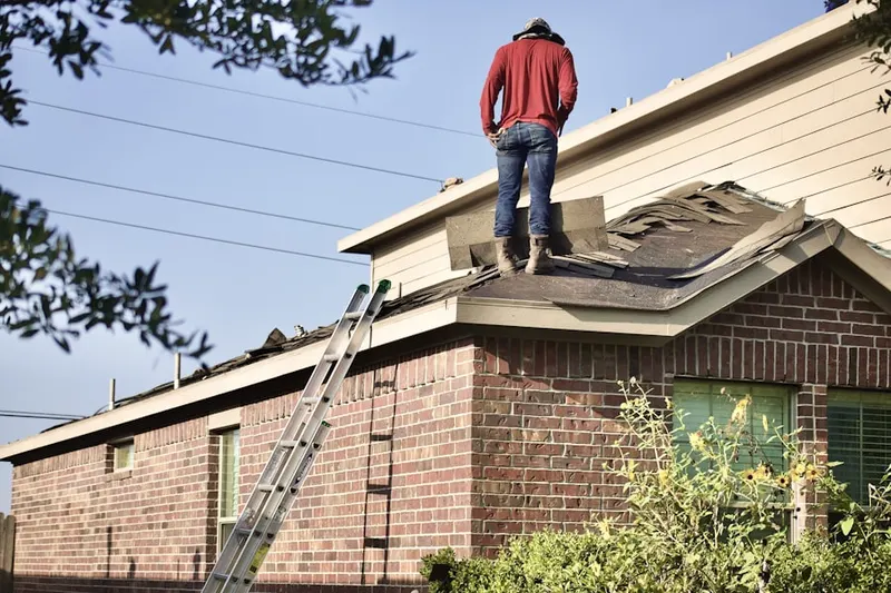 Professional roofer working on a residential roof in Adams